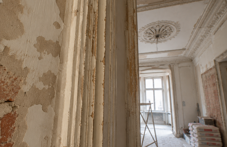 Altbausanierung eines Bestandsgebäudes Altbauwohnung während der Sanierung mit freigelegten Wänden und historischen Stuckelementen